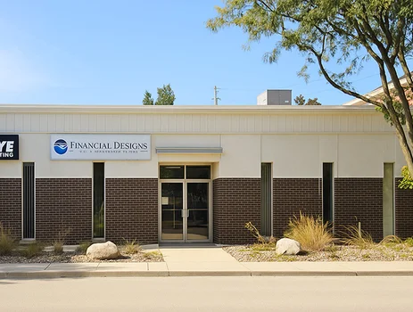 The image shows the exterior of a building with two businesses: "Hawkeye Exterminating" and "Financial Designs." The facade has a combination of brick and light-colored panels, with narrow vertical windows. The area in front has some landscaping, including rocks and plants, and there is a tree to the right.