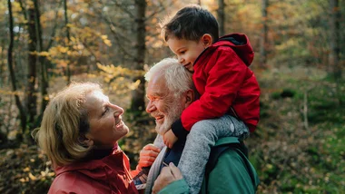 Grandparents with grandchild on grandfather's shoulders